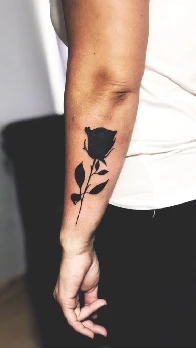 Solid blackwork high-density rose tattoo on an arm